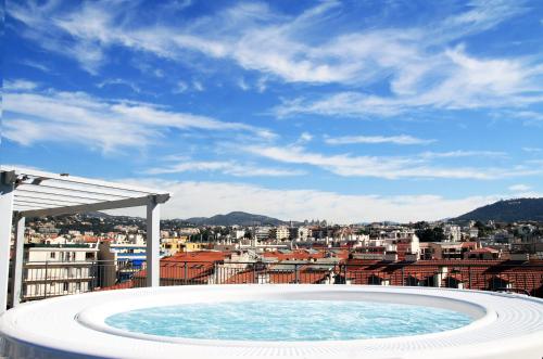 a hot tub with a view of a city at Hôtel Monsigny in Nice