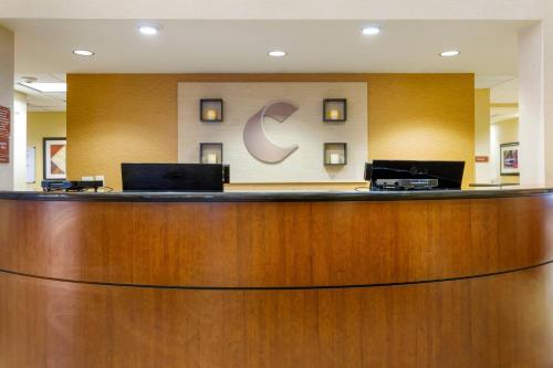 a hotel lobby with a large wooden reception desk at Comfort Suites Charleston West Ashley in Charleston