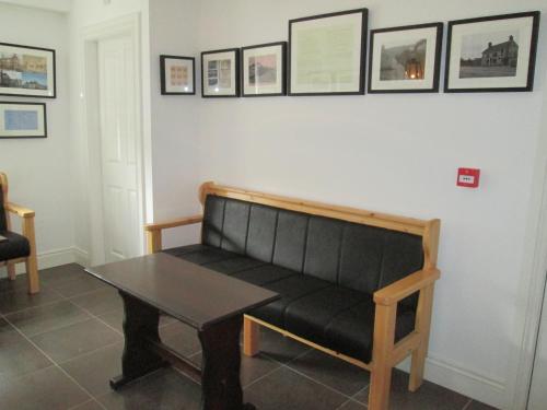 a black bench sitting in a room with a table at The North Pole in Drumfree