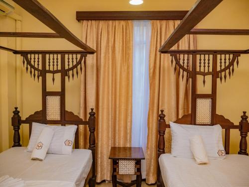 a bedroom with two beds and a window at AfroHaki Homes in Mombasa