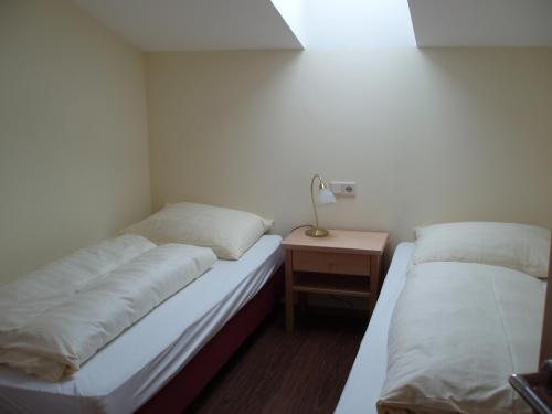 two beds in a room with a lamp on a night stand at smartFLATS in Dorfgastein