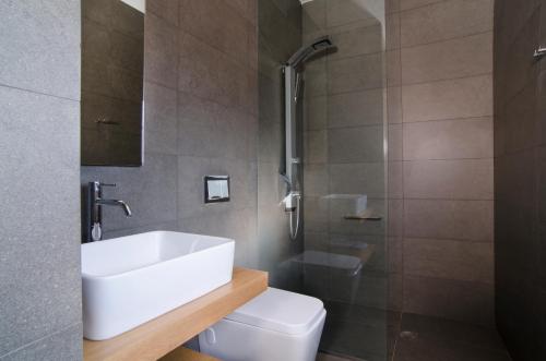 a bathroom with a white sink and a toilet at Seametry Apartments in Souda
