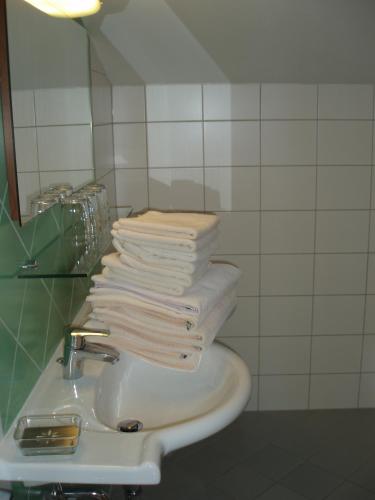 a bathroom with a stack of towels on a sink at smartFLATS in Dorfgastein