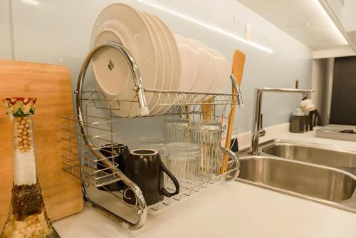 a dish drying rack next to a kitchen sink at Landmark Signature Residences Ori-Stay in Kon Rung (1)