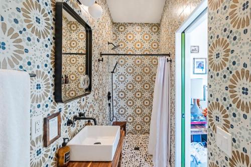 een badkamer met een wastafel en een spiegel bij Retro Vibes, Pool, Spa & Game Room in Twentynine Palms