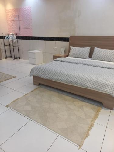 a bedroom with two beds and a rug at إستراحة الريف in Kalbā