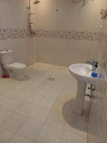 a bathroom with a toilet and a sink at إستراحة الريف in Kalbā