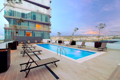 a hotel with a pool and chairs and a building at The View Hotel by Covalia in San Luis Potosí