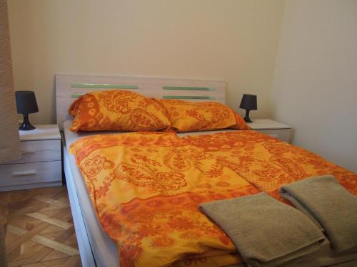 1 cama con edredón naranja y 2 mesitas de noche en Museum Inn, en Praga