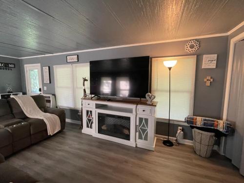 een woonkamer met een bank en een flatscreen-tv bij Lake House Hide Away in Roxboro