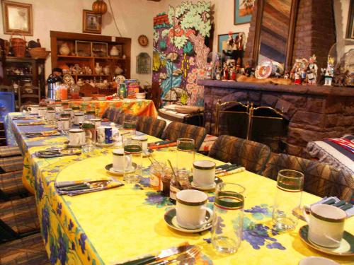 einem langen Tisch mit Tellern und Tassen darauf in der Unterkunft Inn at Halona in Zuni
