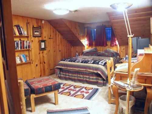 a bedroom with two beds in a room with wooden walls at Inn at Halona in Zuni
