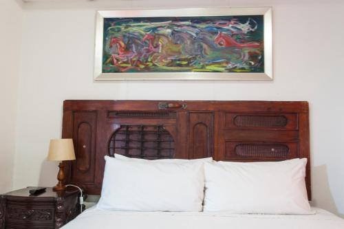 a painting above a bed in a bedroom at La Posada del Arcangel in Managua
