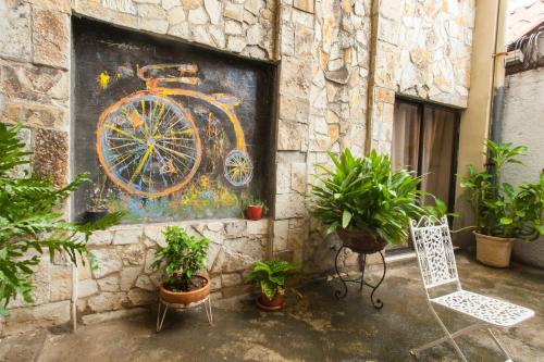 a painting of a bicycle on a wall with plants at La Posada del Arcangel in Managua