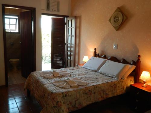 a bedroom with a bed with plates and napkins on it at Enseada Hotel in Ubatuba