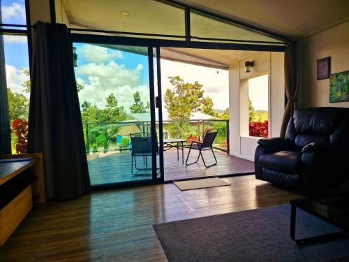 a living room with a sliding glass door to a deck at Hug Doi Homestay Chiang Rai in Chiang Rai