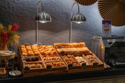 une présentation de différents types de pâtisseries sur un comptoir dans l'établissement WOOVO Phuket Patong - by Swandor, à Patong Beach