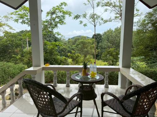 une terrasse couverte avec 2 chaises et une table. dans l'établissement Koh Jum Serenity Resort, à Ko Jum