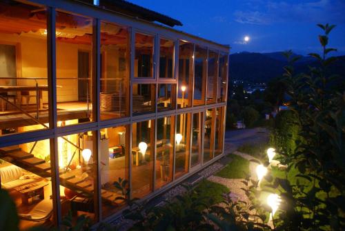 a building with glass windows at night at Haus Bergblick in Fuschl am See
