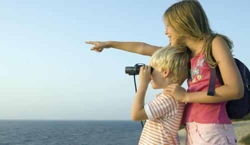 a woman and a child looking at the ocean with a camera at Country Inn & Suites by Radisson, Hiram, GA in Hiram