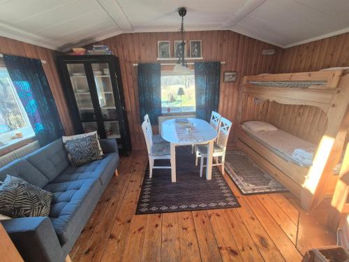 a room with a couch and a table and a bed at Backamgården in Sälen