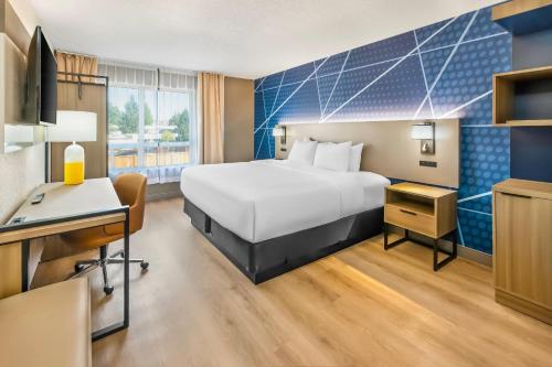 una habitación de hotel con una cama y un escritorio en Comfort Inn, en London