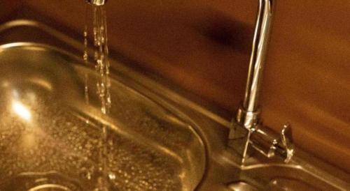 a bathroom sink with water coming out of it at Lodge Raven in Liyama