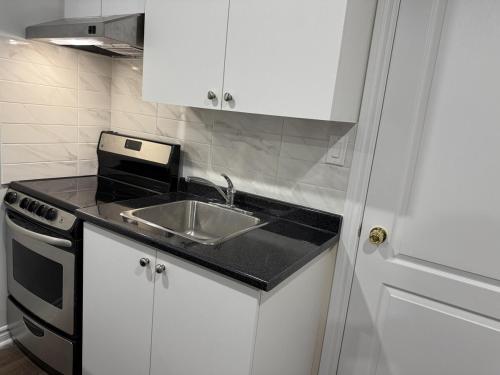 a kitchen with a sink and a stove at Cozy Private Two-Level Suite In Brampton With Separate Entrance And Living Area on Main Floor in Brampton