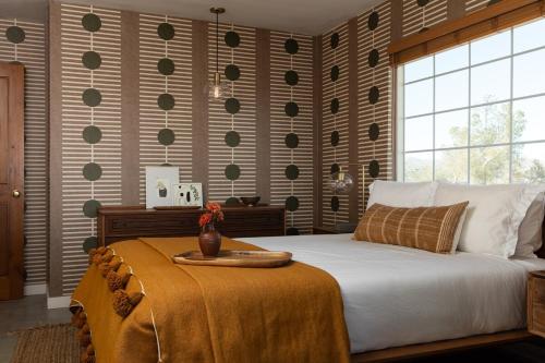 a bedroom with a bed with a tray on it at Stylish, Spa, Cowboy Pool Flamingo Social Club in Yucca Valley