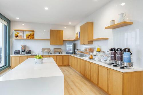 a large kitchen with wooden cabinets and white counter tops at Comfort Inn & Suites Newark Liberty International Airport in Newark