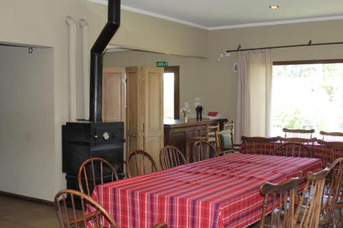 a dining room with a table and chairs and a stove at Quinta El Monte in Tandil