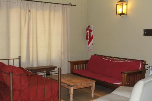 a living room with a red couch and chairs at Quinta El Monte in Tandil