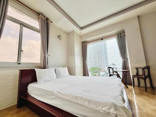 Cái RăngにあるTrường Lộc Hotelのベッドと大きな窓のある寝室