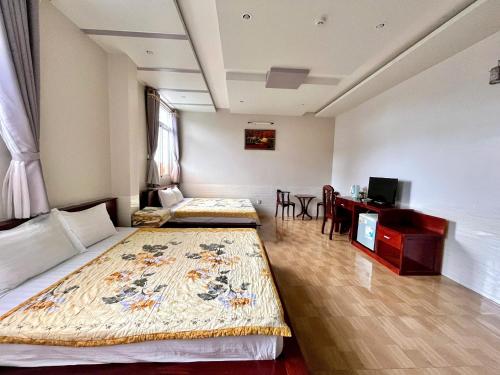 Cái RăngにあるTrường Lộc Hotelのベッド2台と机があるホテルの部屋