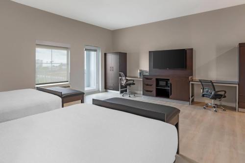 a hotel room with two beds and a flat screen tv at The J Hotel Dunedin Clearwater, an Ascend Collection Hotel in Dunedin