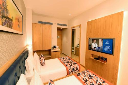 a hotel room with a bed and a tv at hotel Linda Grand Near Delhi Airport, A Block road no 6 street No 12 Mahipalpur New Delhi in New Delhi