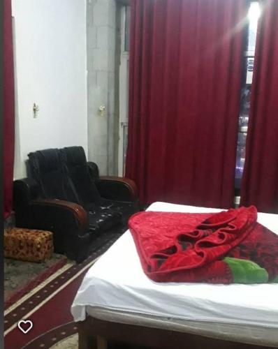 Un dormitorio con una cama y un sofá y una ventana. en فندق ابراج الحجري, en Al Ḩashīshīyah