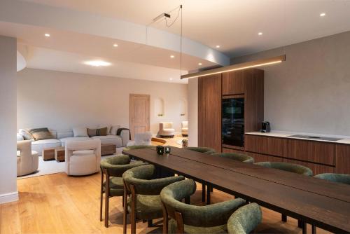 - un salon avec une grande table et des chaises dans l'établissement De Pagode - A Serene Coastal Home with Pool, à Duinbergen