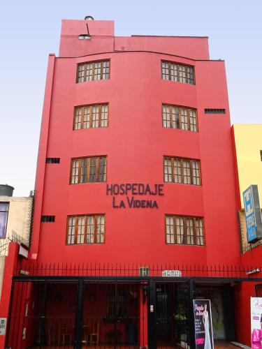 a red building with the words hostelale la vaza at Hospedaje La Videna in Lima