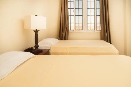 1 dormitorio con 2 camas y ventana en Hampton Apartments Guyana, en Georgetown