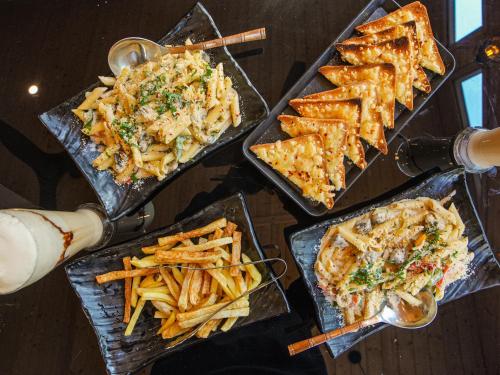 una mesa repleta de platos de comida y patatas fritas en Khanna Residency, en Nueva Delhi
