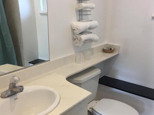 ein Badezimmer mit einem Waschbecken, einem WC und einem Spiegel in der Unterkunft Deluxe Inn Redwood City in Redwood City