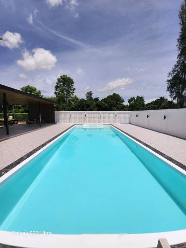a swimming pool with blue water in a building at Sun Moon Tree Resort & Recreation in Ban Khok Sung