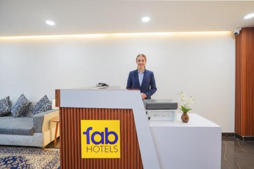 a woman standing at a reception desk in a hotel room at FabHotel The Royal - Near Greater Kailash Metro in New Delhi