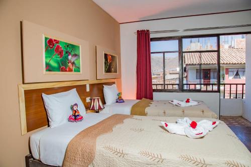 duas camas num quarto com dois cisnes em Euler House`s em Cusco