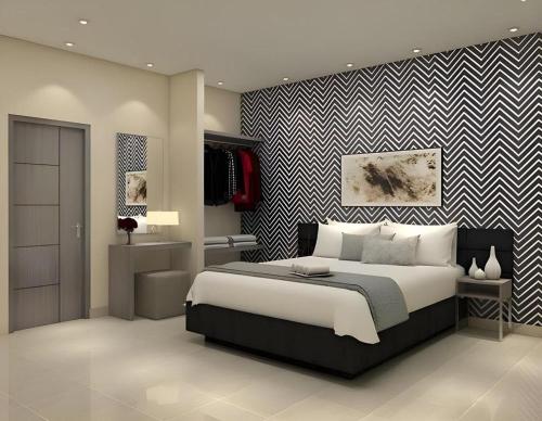 a bedroom with a large bed and a striped wall at Smart Budget Hotel in Stasiun Tawang