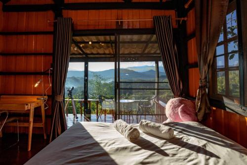 a man laying on a bed in a room with a large window at Flower hill 180 in Chiang Rai