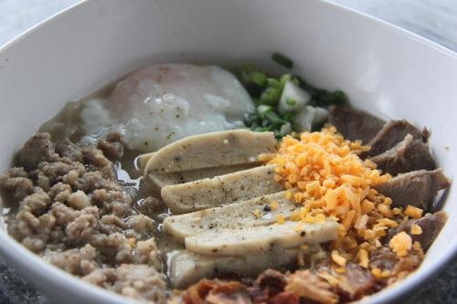 uma tigela de alimentos com carne, arroz e legumes em Cozy Rabbit Hotel em Thung Song