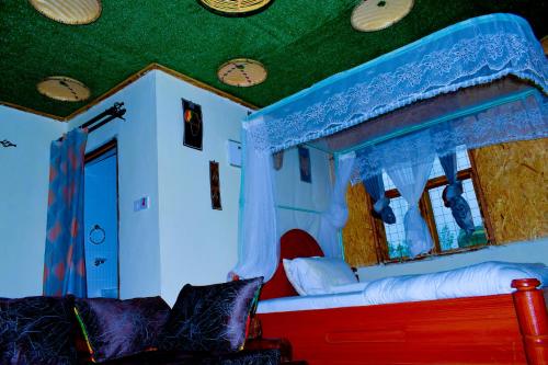 Hakuna Matata Gardens في Migori: غرفة بسرير على شكل منزل