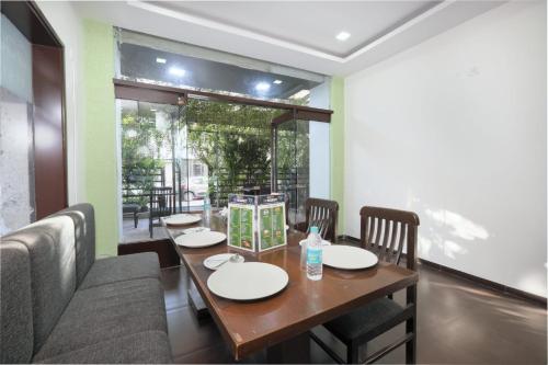 Un comedor con mesa y sillas de madera. en Hotel PALMVIEW RESIDENCY, en Vadodara